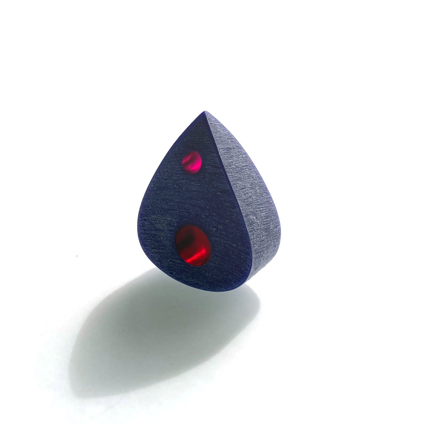 big thick and black guitar pick with 2 red color optics along the spine