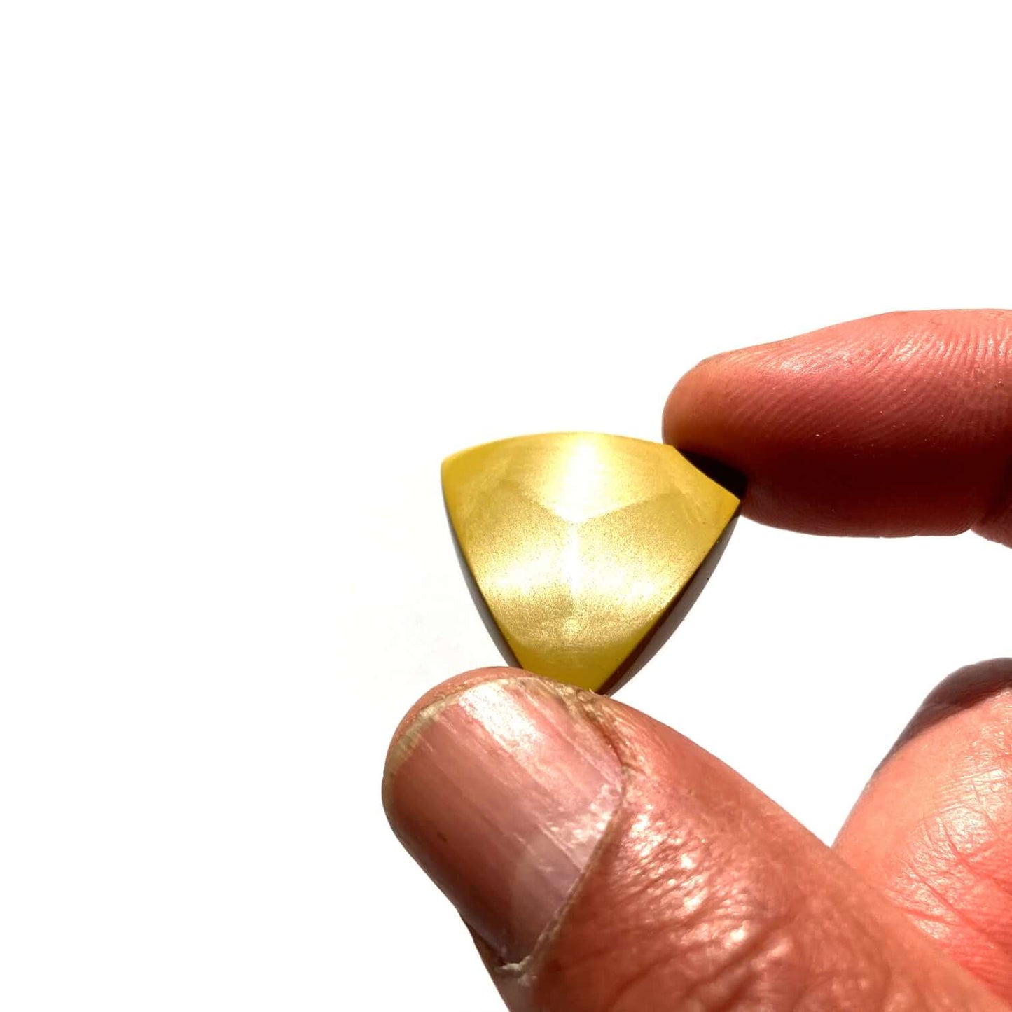 Torlon 4203 guitar plectrums held between fingers against a white background.