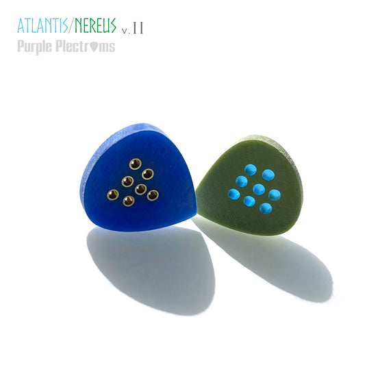 pair of green and blue guitar picks with brass and color optics