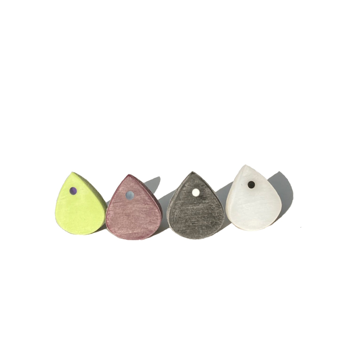 four small guitar picks with a single color optics standing