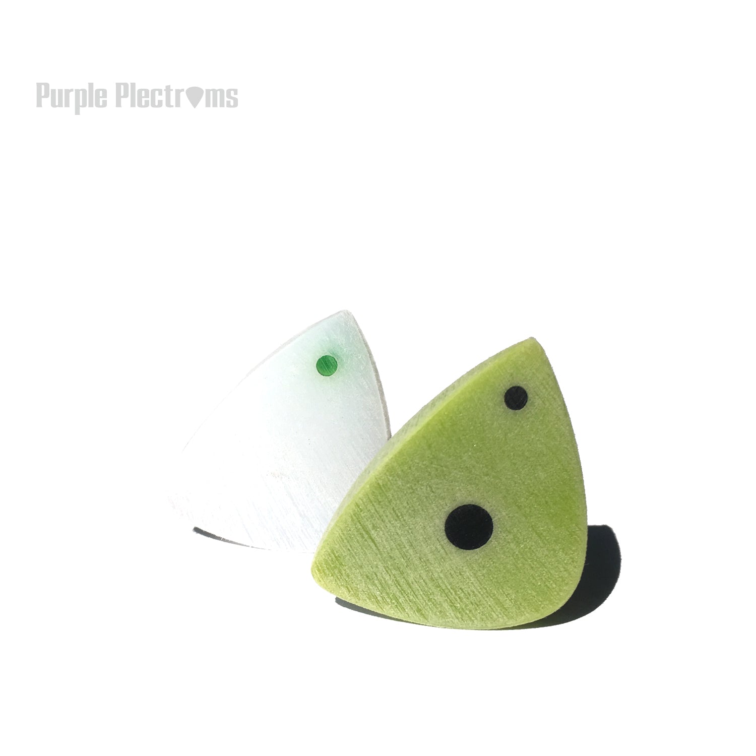 pair of guitar green and white guitar picks bathed in sun