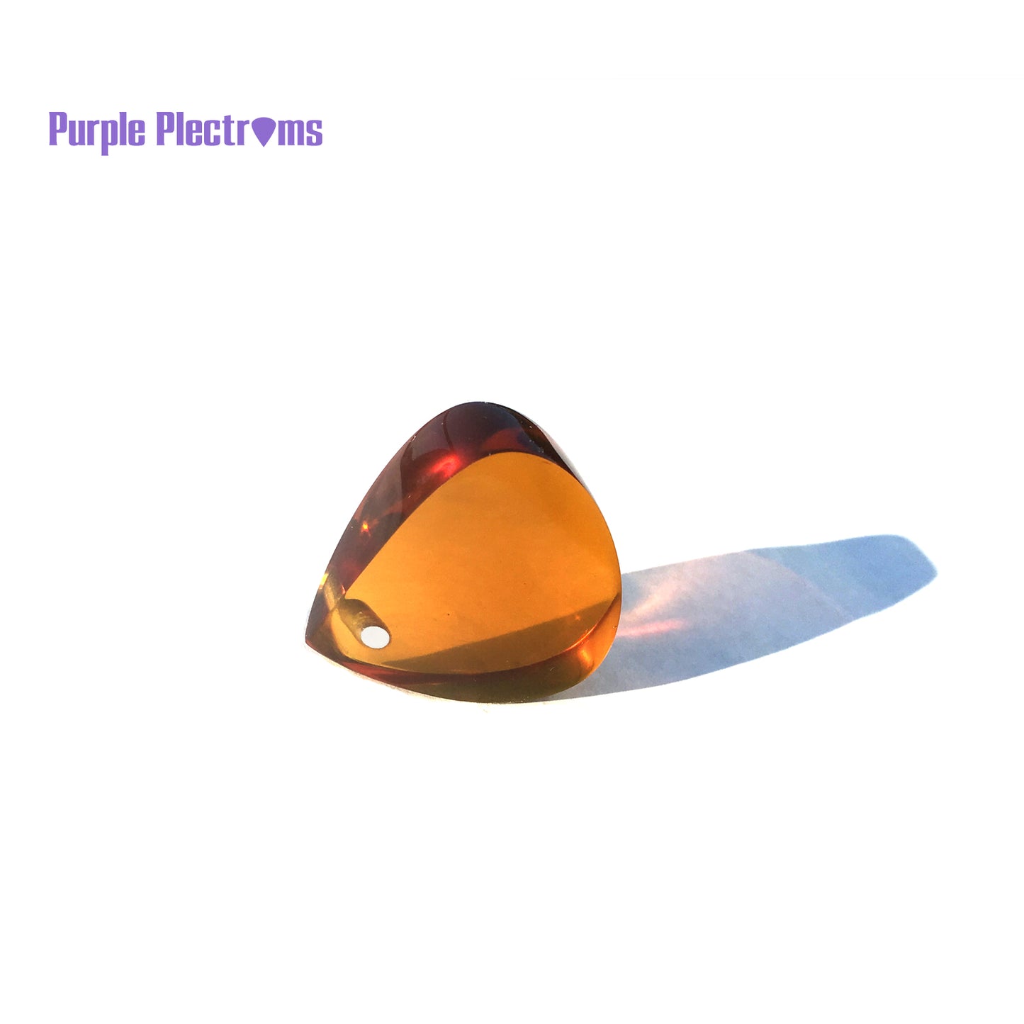 amber color guitar pick made from ultem with an aluminum insert near the tip