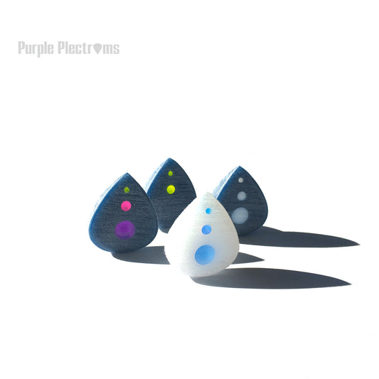 group of four small guitar picks with multicolor optics