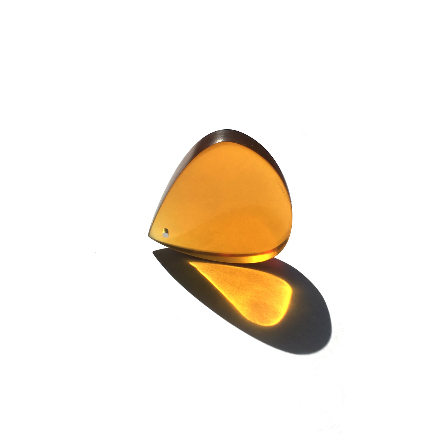 amber color guitar pick made from ultem with an aluminum insert near the tip